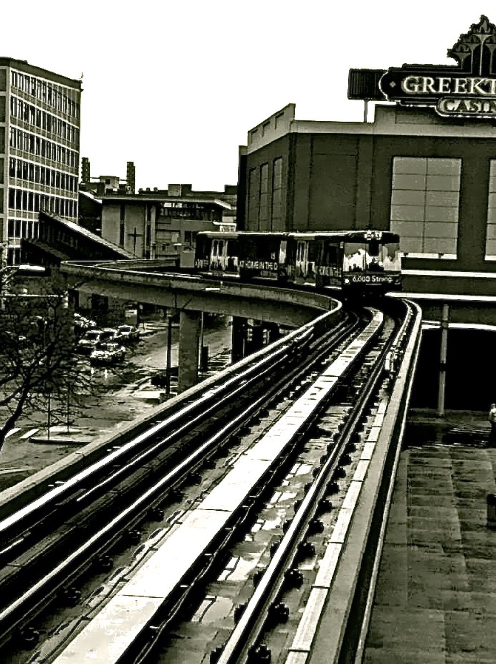 Archival view of a People Mover train curving along the elevated track in Greektown
